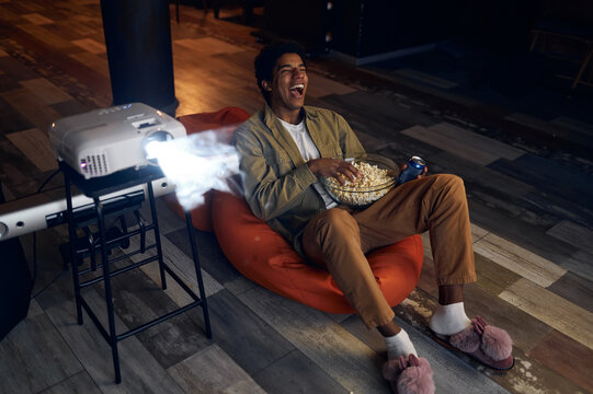 Happy young man laughing during watch film