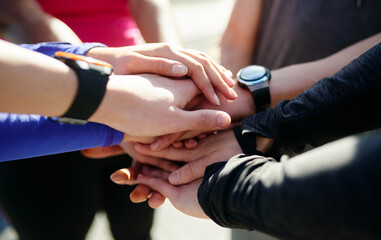 Obraz premium Start stacking. Closeup of a group of unrecognizable peoples hands forming a huddle outside during the day.