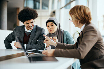 Young Middle Eastern couple having meeting with their financial advisor in office.