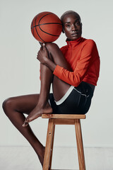 Fototapeta premium Lets meet up at the court. Studio shot of an attractive young woman playing basketball against a grey background.