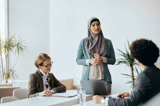 Young Middle Eastern businesswoman communicating with her colleagues during a meeting at corporate office.