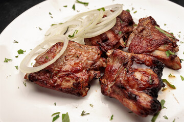 Grilled pork ribs with herbs on a dark background