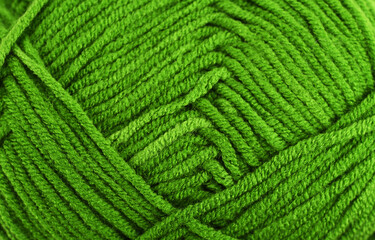Green knitting wool close-up.Green yarn clew close up texture. Blue wool background.