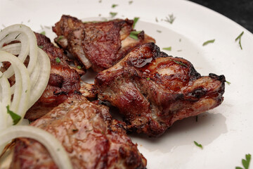 Grilled pork ribs with herbs on a dark background