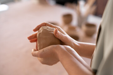 close-up of female potter's hand. professional ceramist at work using handmade cup making tools in studio, selective focus. the formation of handmade dishes. Art and small business concept