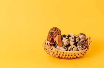 Easter holiday mockup design. Handmade duck shaped straw basket with marble quail eggs. Yellow background. Interior decor. Healthy organic food. Business card. Copy space. Empty text place. Postcard