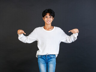 Studio closeup shot of Asian young LGBTQ gay glamour bisexual homosexual male model in casual outfit standing smiling holding two hands and fingers pointing blank copy space on black background