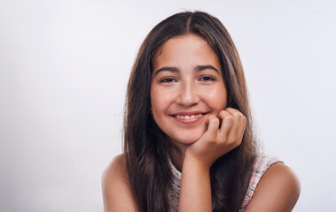 Fototapeta premium Confidence is the new beautiful. Cropped portrait of an attractive teenage girl standing alone against a white background in the studio.