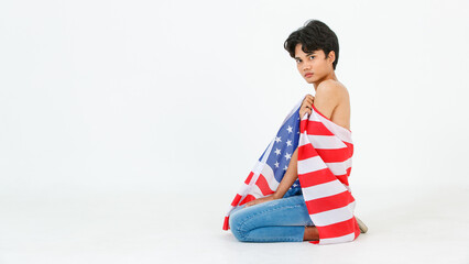 Portrait studio shot of Asian young LGBT gay bisexual homosexual male fashionable model in casual outfit sitting smiling using United States of America US national flag cover body on white background