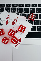 Online gaming app, casino and gambling business. Cards and dice on a laptop. Vertical image