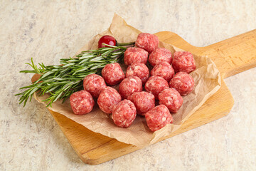 Raw uncooked beef meatballs served rosemary