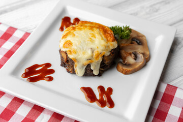 Delicious veal cutlet with melted mozzarella cheese on white plate
