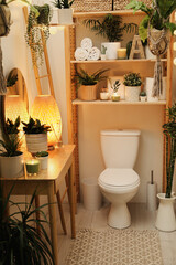 Stylish bathroom interior with toilet bowl and green plants