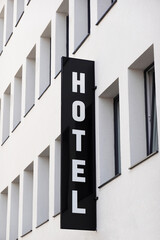 vertical hotel sign on generic modern city hotel facade