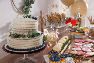 Baby shower party. Different delicious treats on wooden table indoors