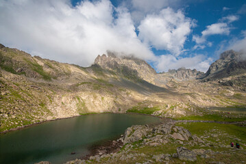 Fototapeta na wymiar Lakes formed when the snow melted in a spring weather with white clouds in the blue sky. Lakes formed at the summit. Kackar Mountains. Verçenik Gate Lakes. Rize, Turkey.
