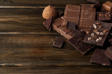 Broken chocolate bars on dark wooden background