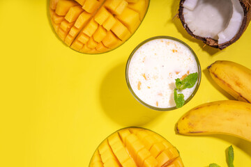 Refreshing yogurt, milkshakes or smoothies. Three glasses with fruit milkshakes. White banana, green apple avocado, yellow mango tropical fruits smoothie. On bright yellow table, copy space