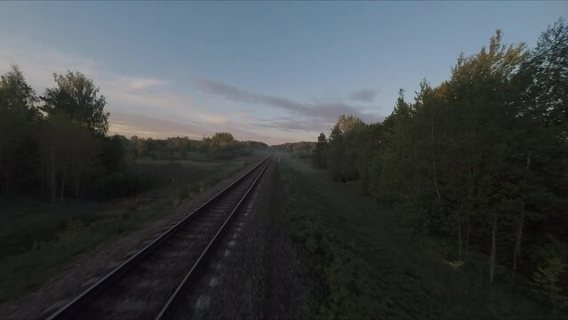 Flying over the bridge and the river on a drone. Flying along the railway rails. Flight at sunset. A sunny summer day. Aerial photography . FPV flights. High-speed flights on a drone.