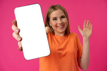Young smiling woman showing blank screen smartphone in studio