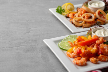 Cooked seafood on plate on gray background