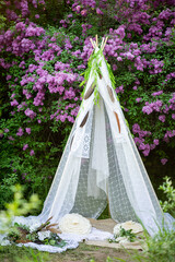 decorative wigwam house in nature. lilac in the park