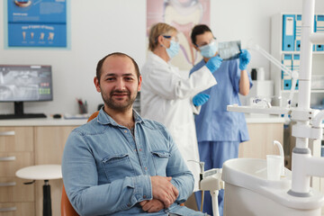 Obraz premium Portrait of man patient with caries infection sitting on chair waiting to start medical procedure during stomatological examination in orthodontic office, Concept of medicine services