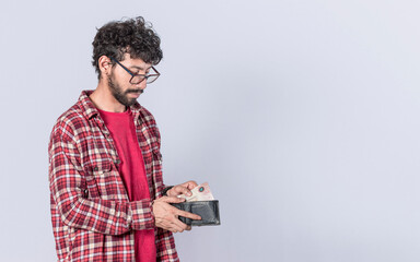 man taking bills out of his wallet, a guy taking money out of his wallet on isolated background