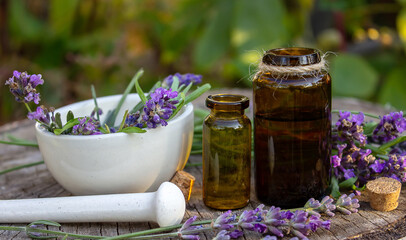 Herbal oil and lavender flowers on a wooden background. Nature.