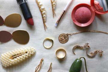 Fototapeta na wymiar Various gold jewelry, personal accessories and beauty products on neutral background. Flat lay.