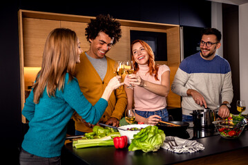 Group of friends preparing vegetarian meal in a kitchen at home.