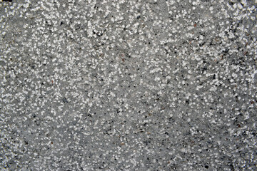 The texture of the concrete part of the fence with small crumbs of stone. Textured background of a cement fence with stone chips of different sizes.