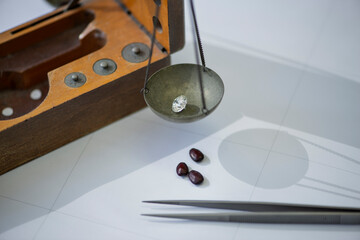 Weight for diamonds , Specialist measures the weight of gems on a jewelry scale , Close-up workflow...
