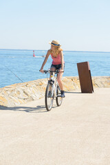 Obraz na płótnie Canvas a woman cycling at seaside
