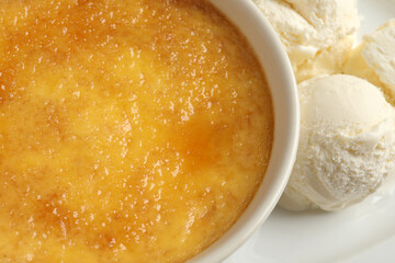 Delicious creme brulee and scoops of ice cream on plate, closeup
