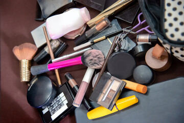 Pile of messy cosmatics makeup on table