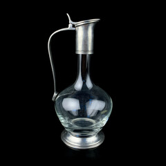 antique glass decanter with a metal figured neck. retro decanter for alcohol on a black isolated background