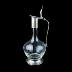 antique glass decanter with a metal figured neck. retro decanter for alcohol on a black isolated background