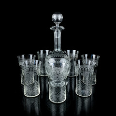 antique glass decanter with geometric pattern. retro decanter for alcohol on a black isolated...