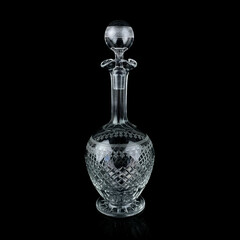 antique glass decanter with geometric pattern. retro decanter for alcohol on a black isolated...