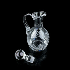 antique glass decanter with geometric pattern. retro decanter for alcohol on a black isolated background. engraved vintage decanter