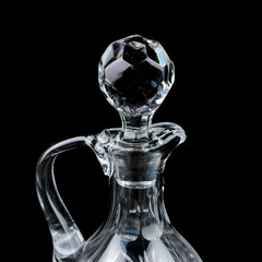 antique glass decanter with geometric pattern. glass faceted lid from gcarafe close-up on a black isolated background