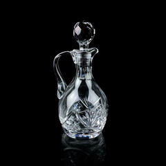 antique glass decanter with geometric pattern. retro decanter for alcohol on a black isolated background. engraved vintage decanter