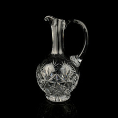 antique glass decanter with geometric pattern. retro decanter for alcohol on a black isolated...