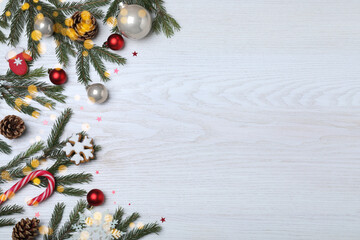 Flat lay composition with fir branches and Christmas decor on white wooden background, space for text. Greeting card design