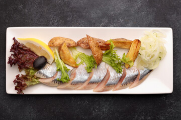 Pickled Herring with baked potatoes, onions and lettuce
