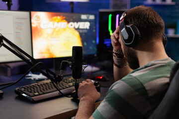 Person losing video games on live stream with chat. Man using headphones and microphone to...