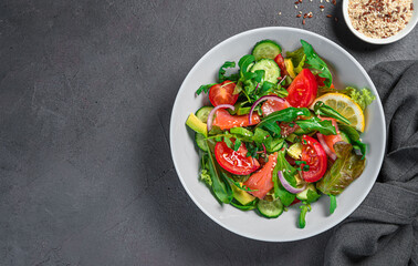 Vegetable salad with salmon, fresh herbs and sesame and flax seeds.