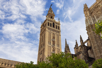 Fototapeta na wymiar Seville's Cathedral with the Giralda and the Giraldillo. On the tower part of the inscription is visible which says The name of the Lord is a fortified tower