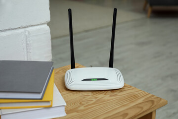 Wi-Fi router on wooden table in room - obrazy, fototapety, plakaty